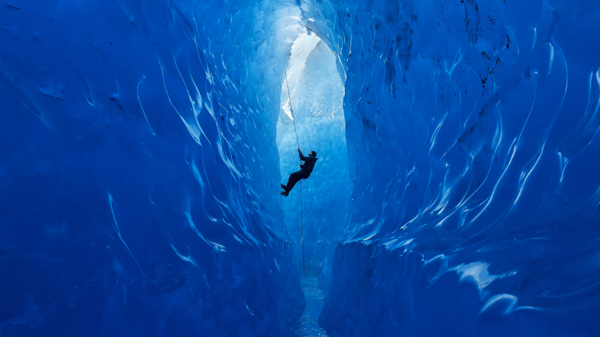 A climber rappels into an ice cave on the Mendenhall Glacier, Alaska, USA