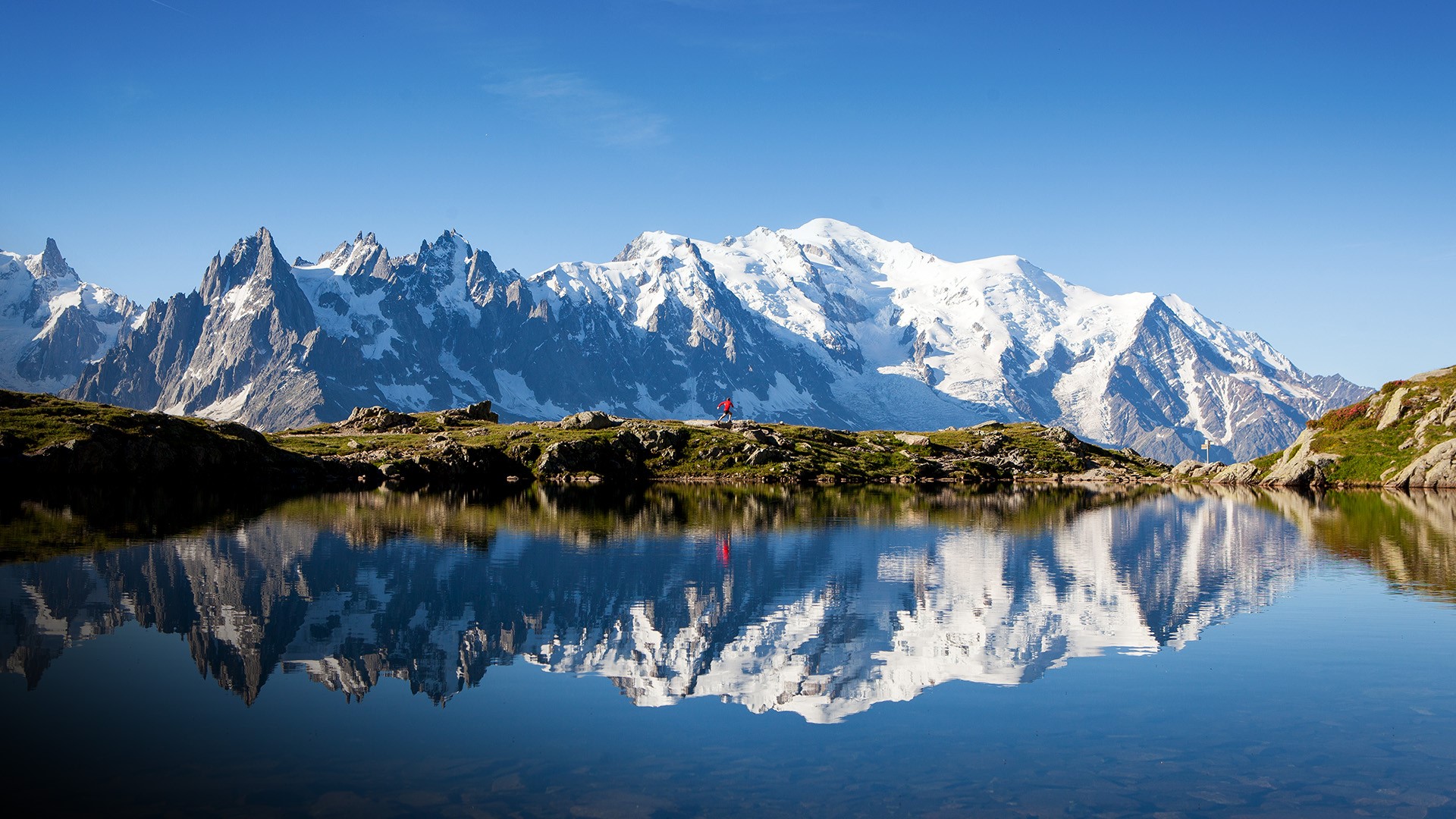 Runner in red runs in the French Alps near Chamonix, Mont Blanc, France