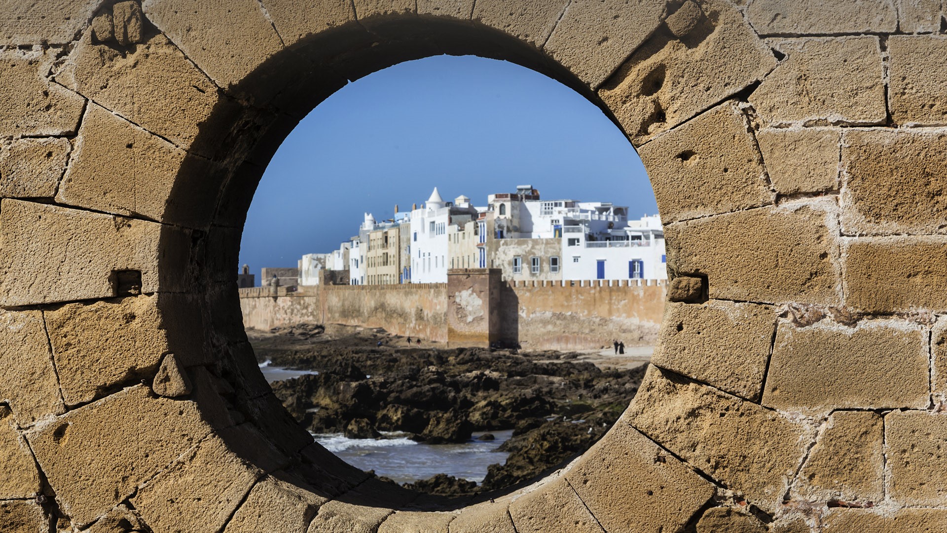 The fortified city of Essaouira view through hole in brick wall, Morocco