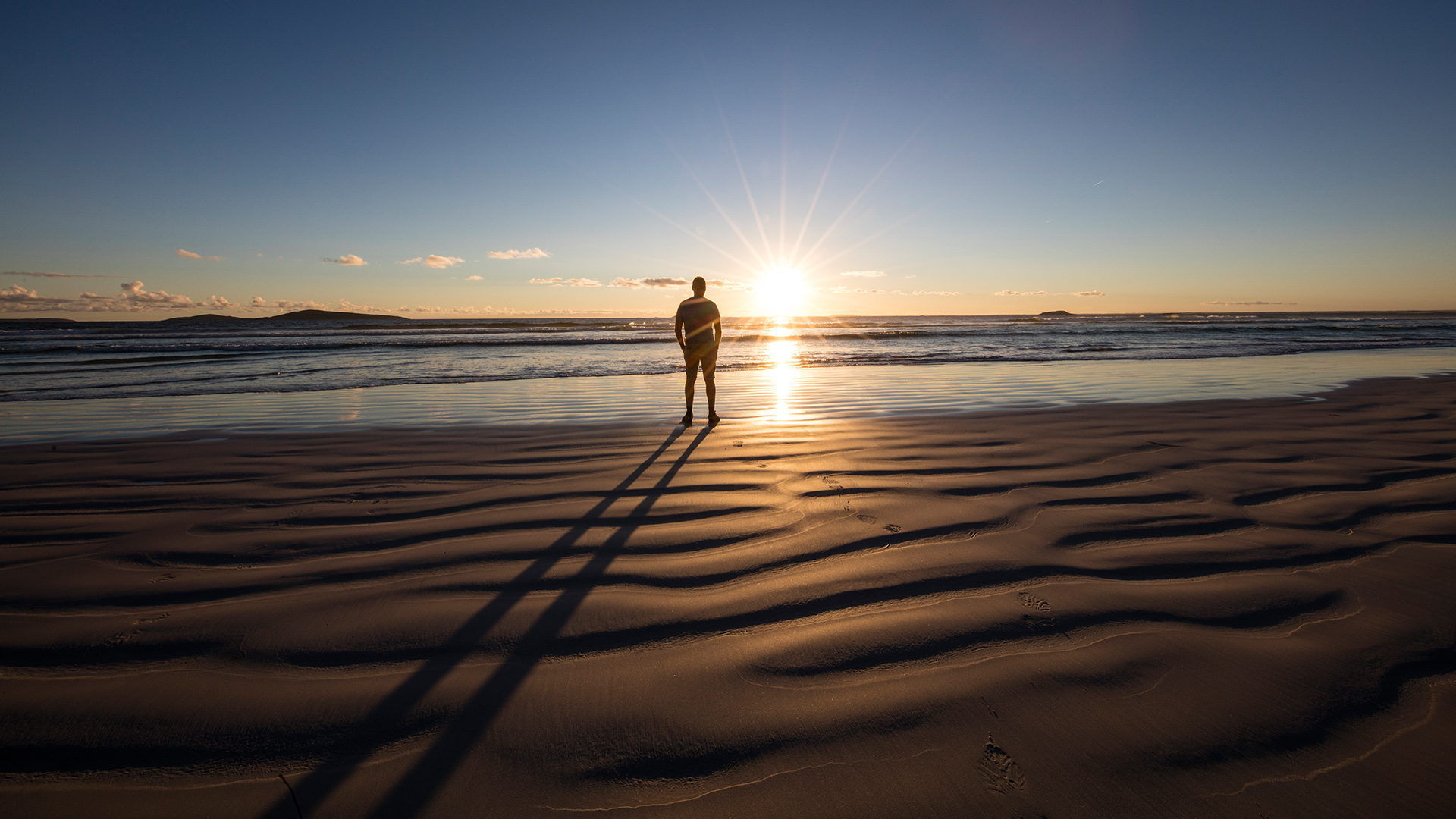 Man standing on beach looking at the sunset, Western Australia