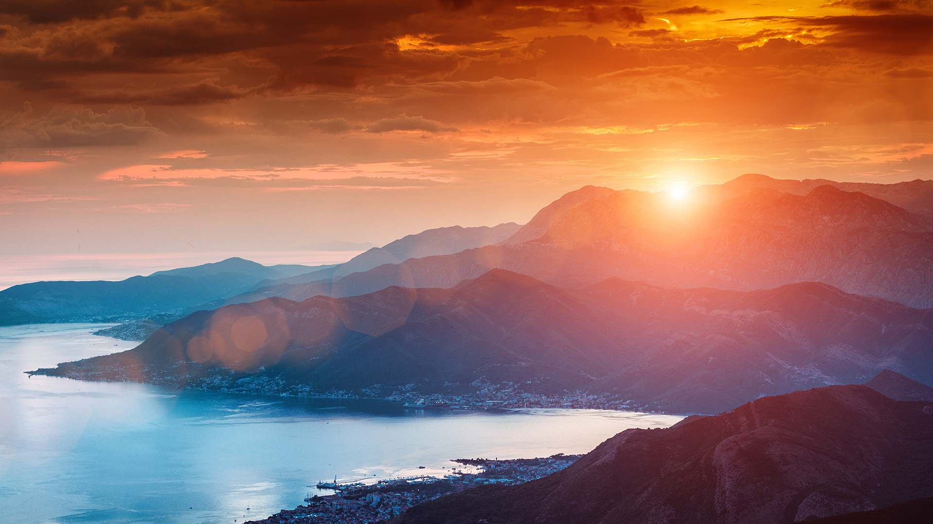 Sun beams through clouds, summer sunset at Kotor's bay, Montenegro